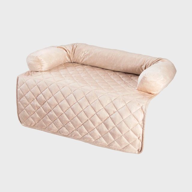 Cushioned armrest with quilted padding rests on a flat surface, featuring a soft, beige material in a plain, neutral background.