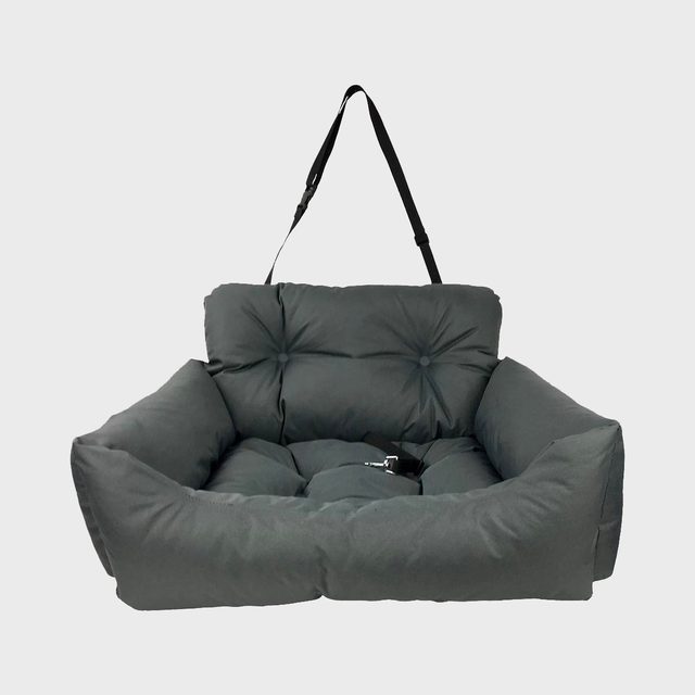 Plush pet seat with strap rests against a white background, featuring soft cushioning and tufted button details.
