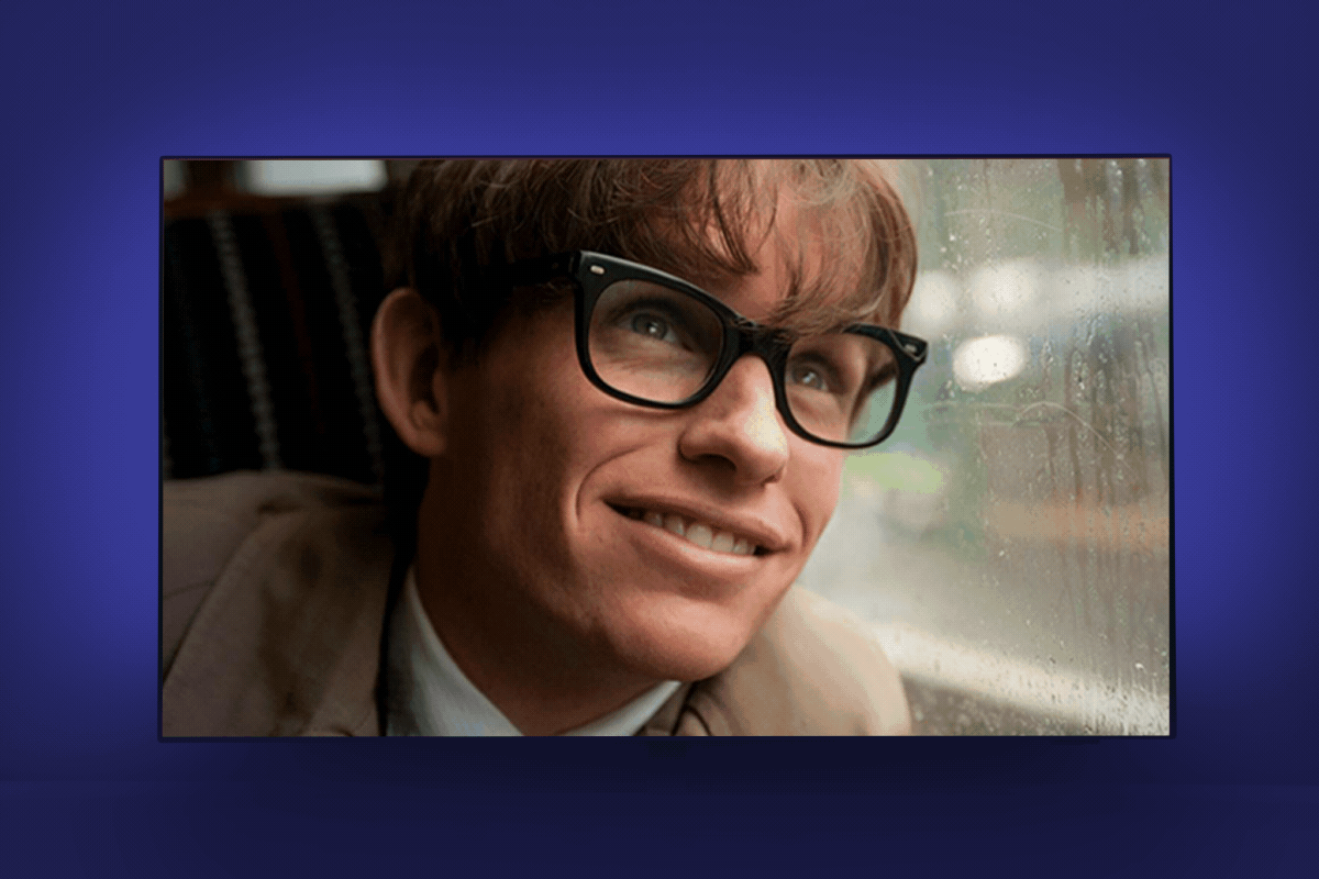 A bespectacled person smiles warmly, peering out a rain-streaked window. The background suggests a cozy indoor setting.