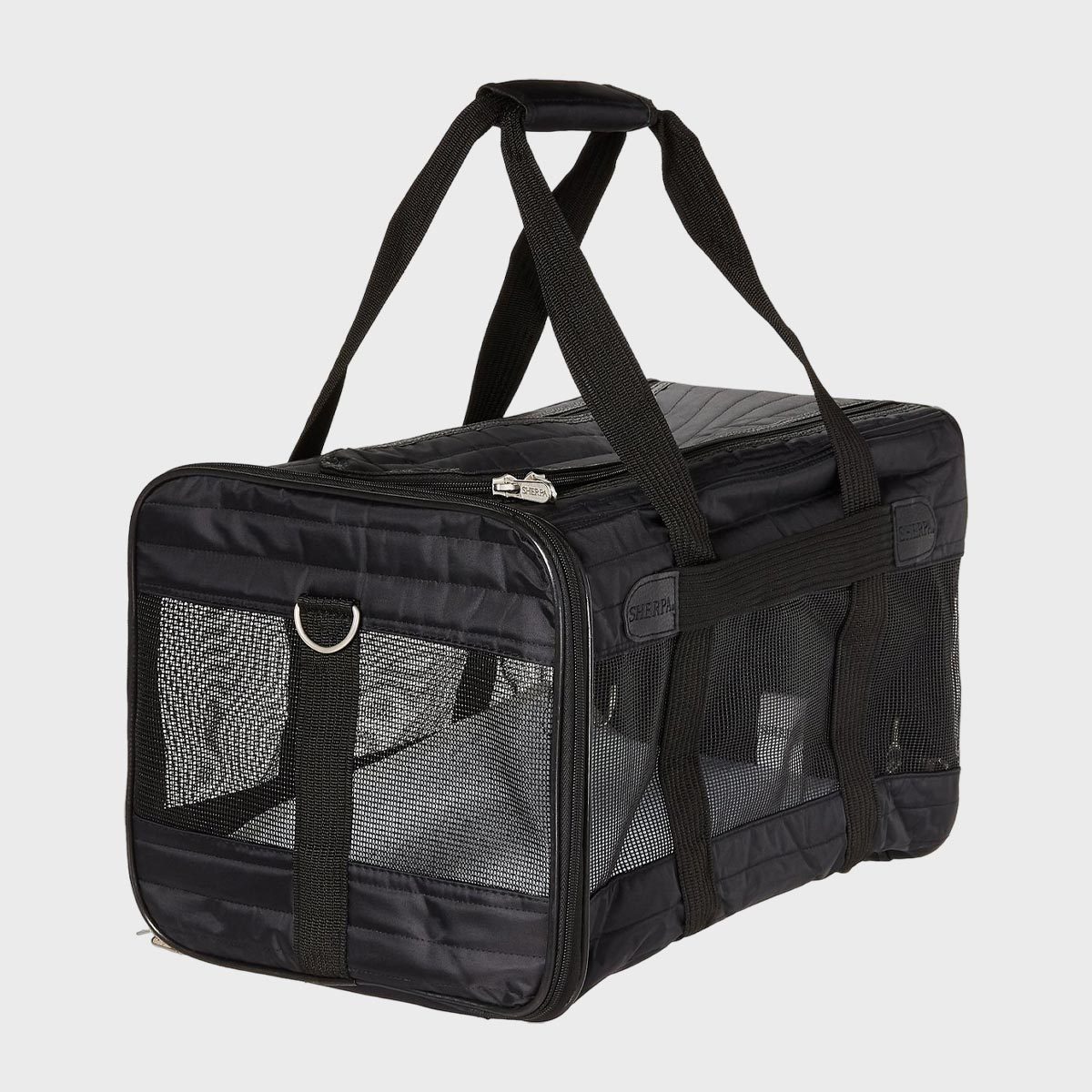 Black pet carrier with mesh sides sits on a plain background, featuring sturdy handles and a zipper. "Sherpa" label visible on the side.
