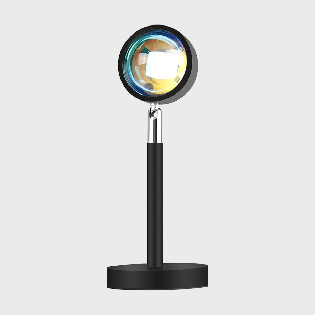 Circular lamp projects multicolored light, resting on a black cylindrical stand, against a plain gray background.