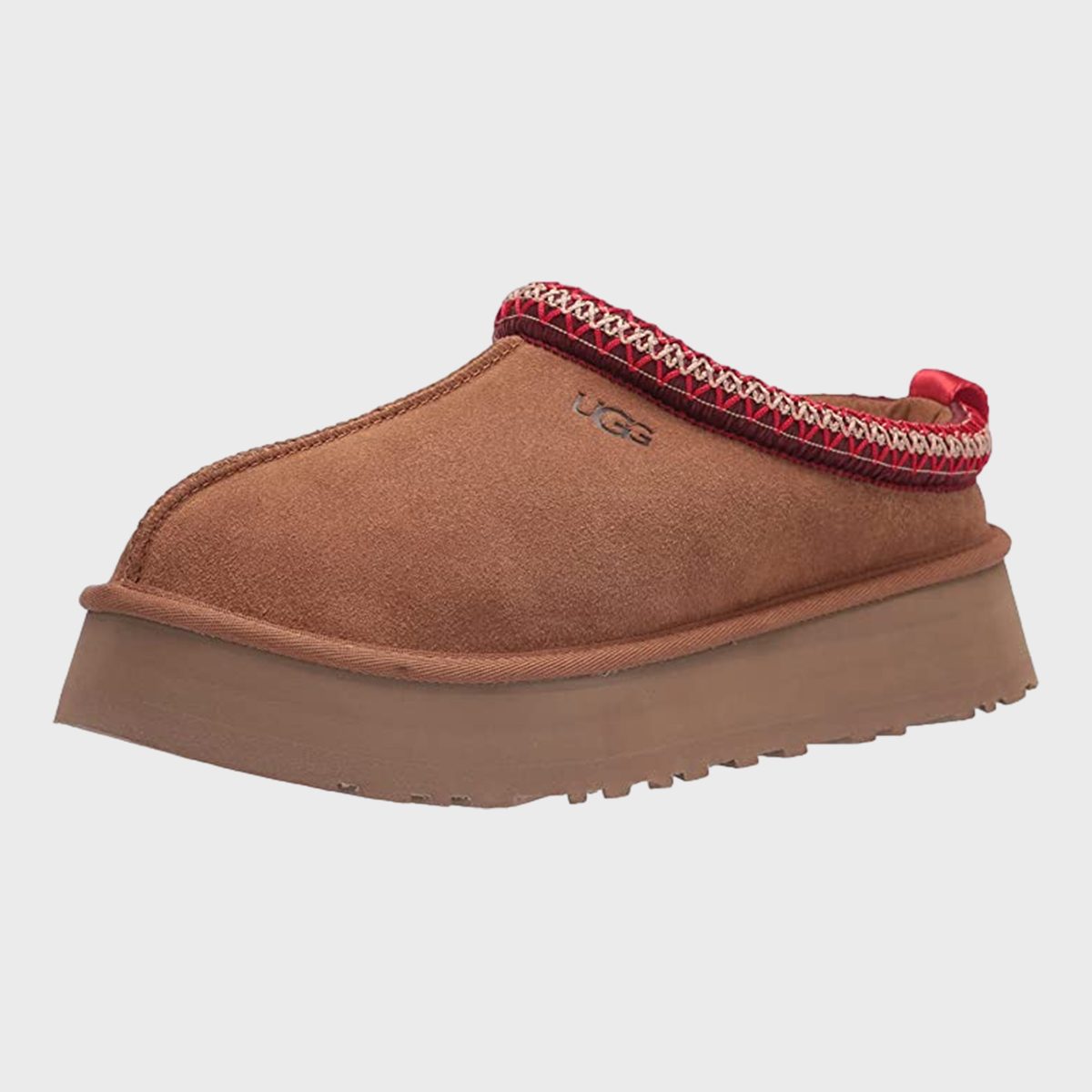 Brown suede slipper with red trim, elevated sole, and visible "UGG" logo; displayed against a plain white background.