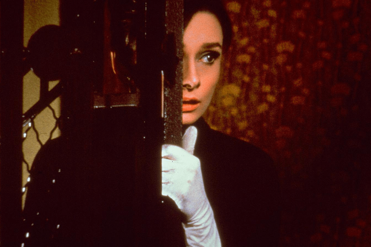 A woman peeks cautiously from behind a door, clad in white gloves, set against a dark, intricate background.