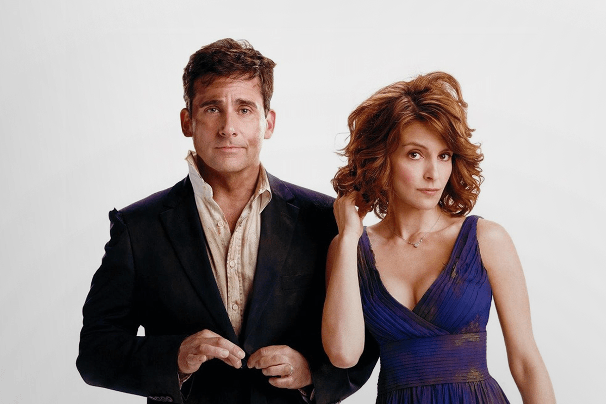 Two people stand side by side. The man adjusts his jacket; the woman touches her hair, both with neutral expressions against a plain backdrop.