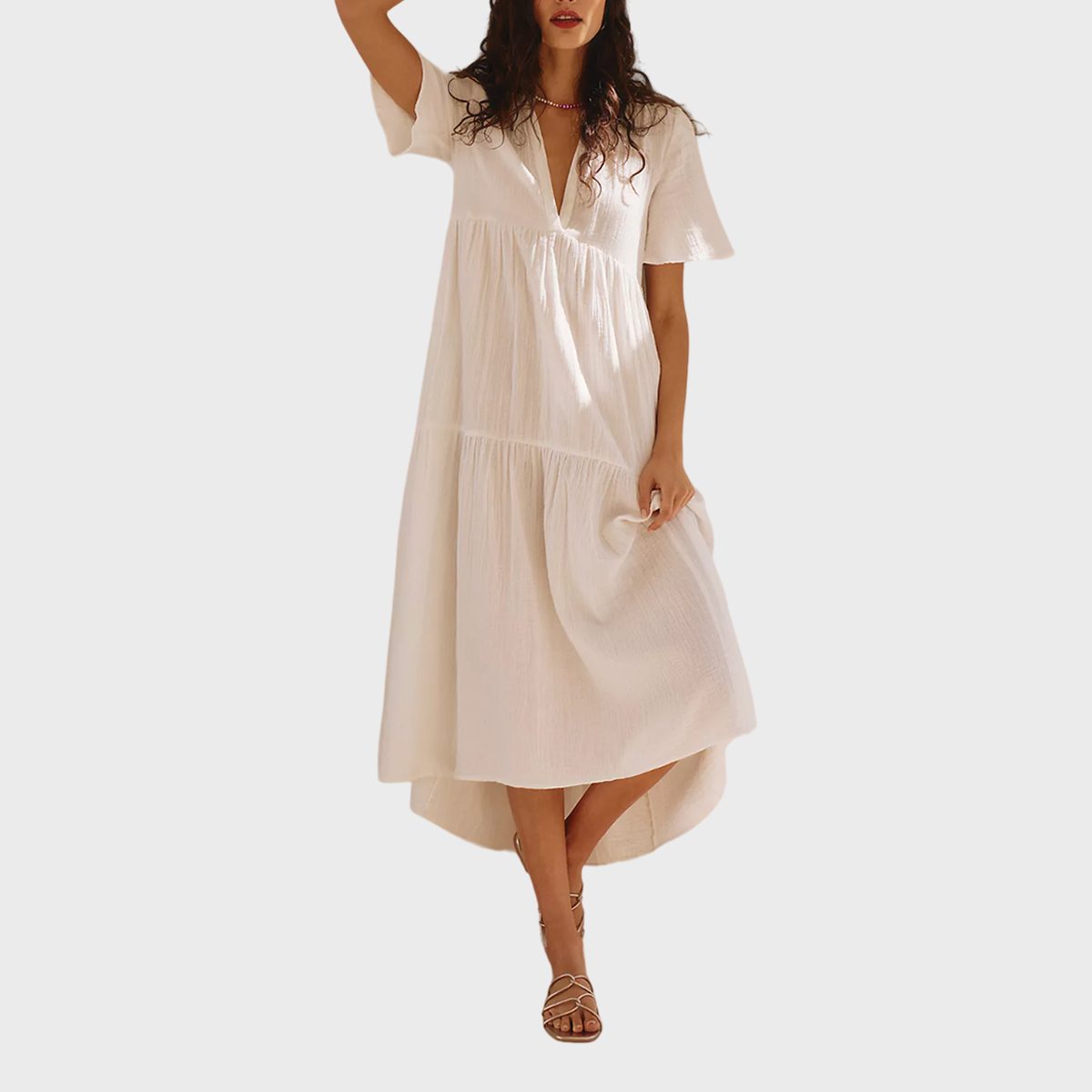 White dress sways gently, worn by a standing person on a neutral gray background.
