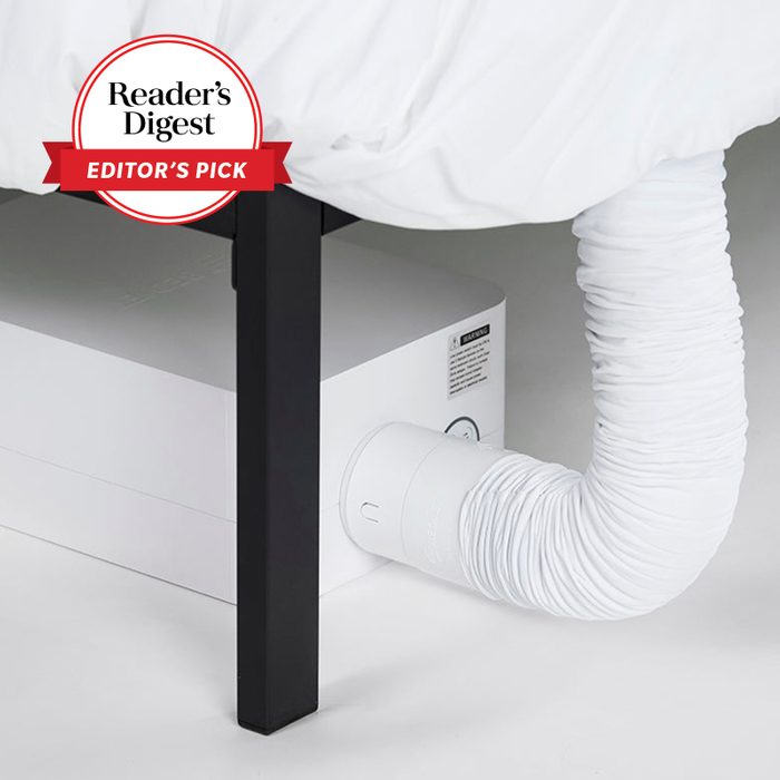 A white hose connects to a rectangular device under a bed, marked as 