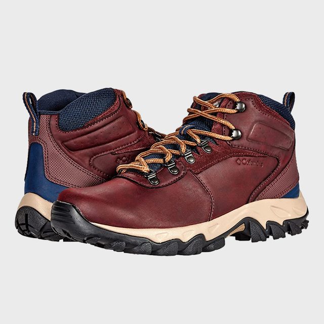 Brown hiking boots with tan laces rest side by side on a plain gray background.