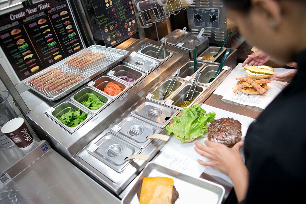 A Manager prepares customized burgers in the McDonald's kitchen