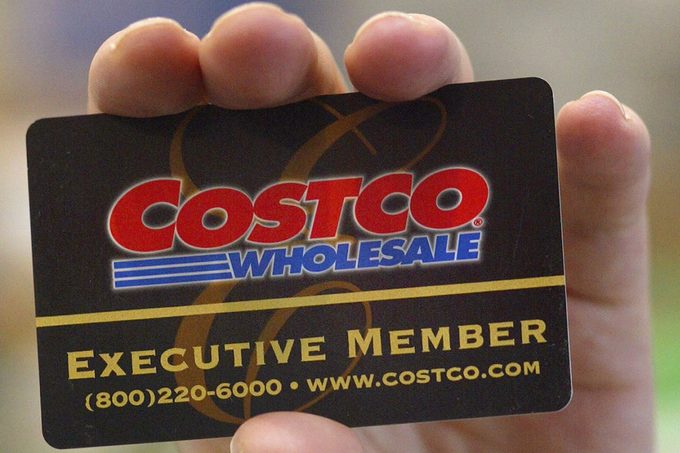 A shopper displays her Costco Wholesale membership card as she enters a Costco Wholesale store