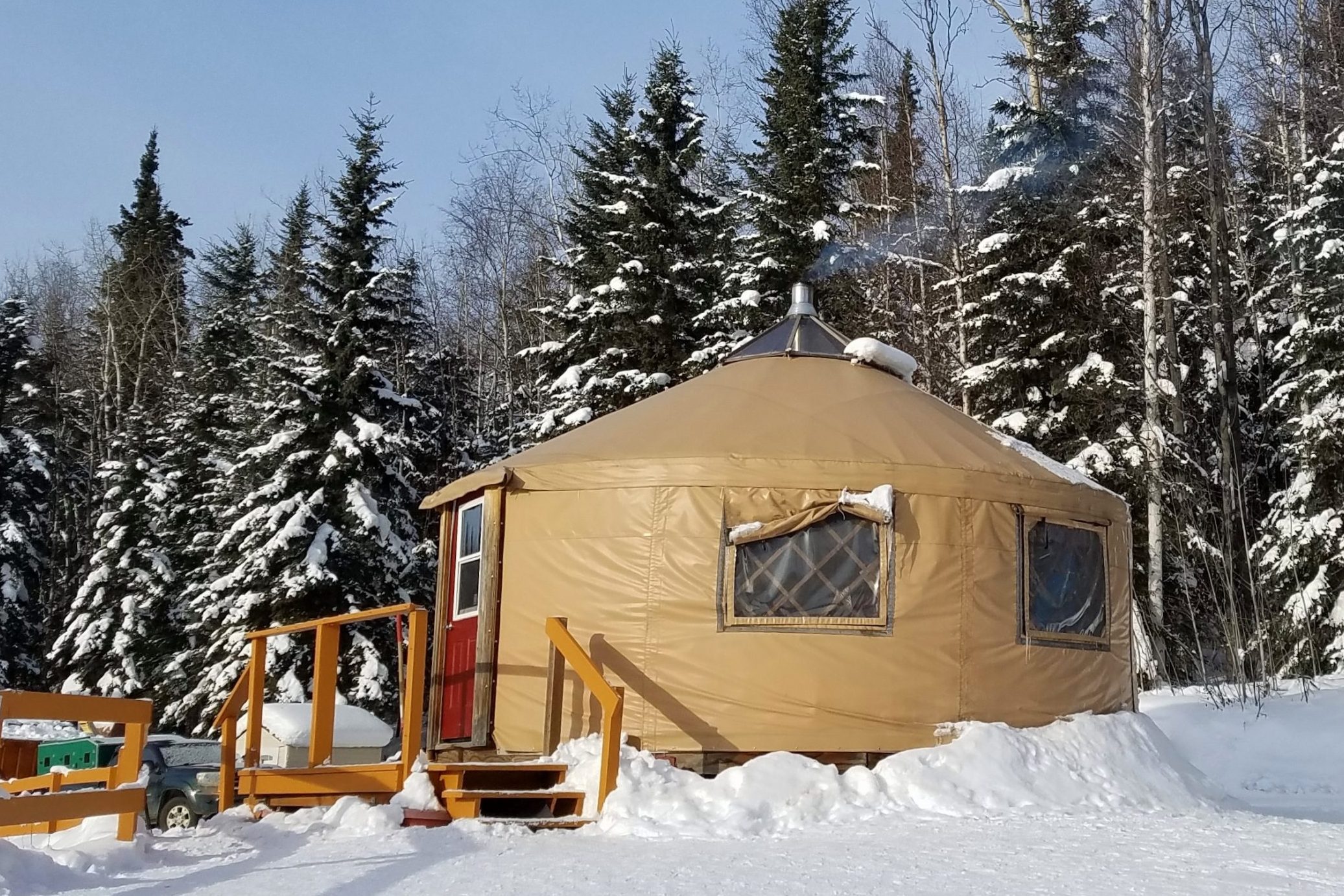 Small Circular Housing, a Yurt, in a Snowy Evergreen Setting
