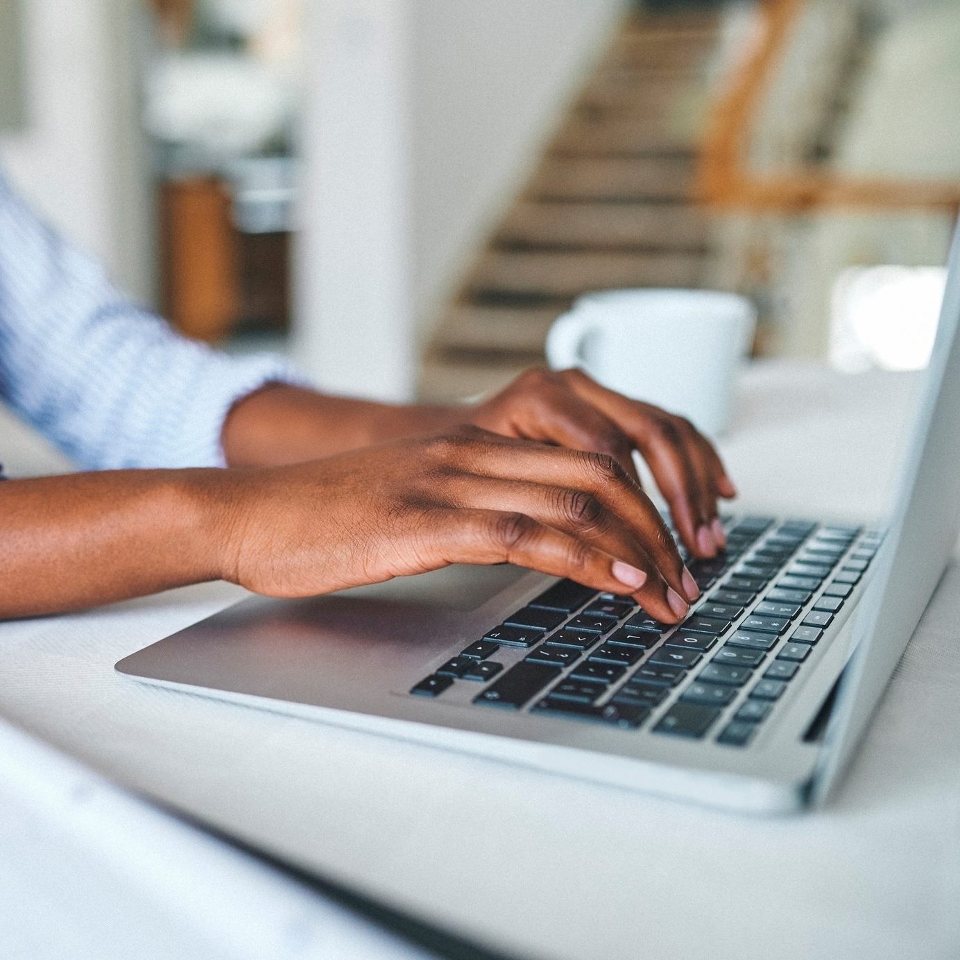 Closeup shot of an unrecognisable woman using a laptop at home