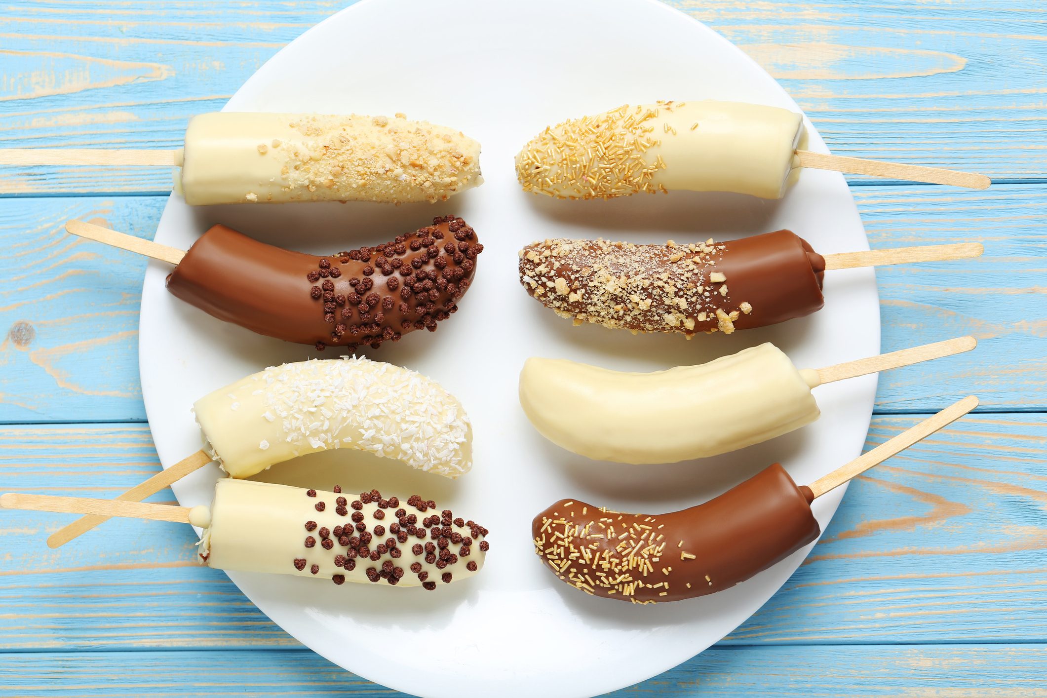 Banana covered in chocolate on a blue wooden table