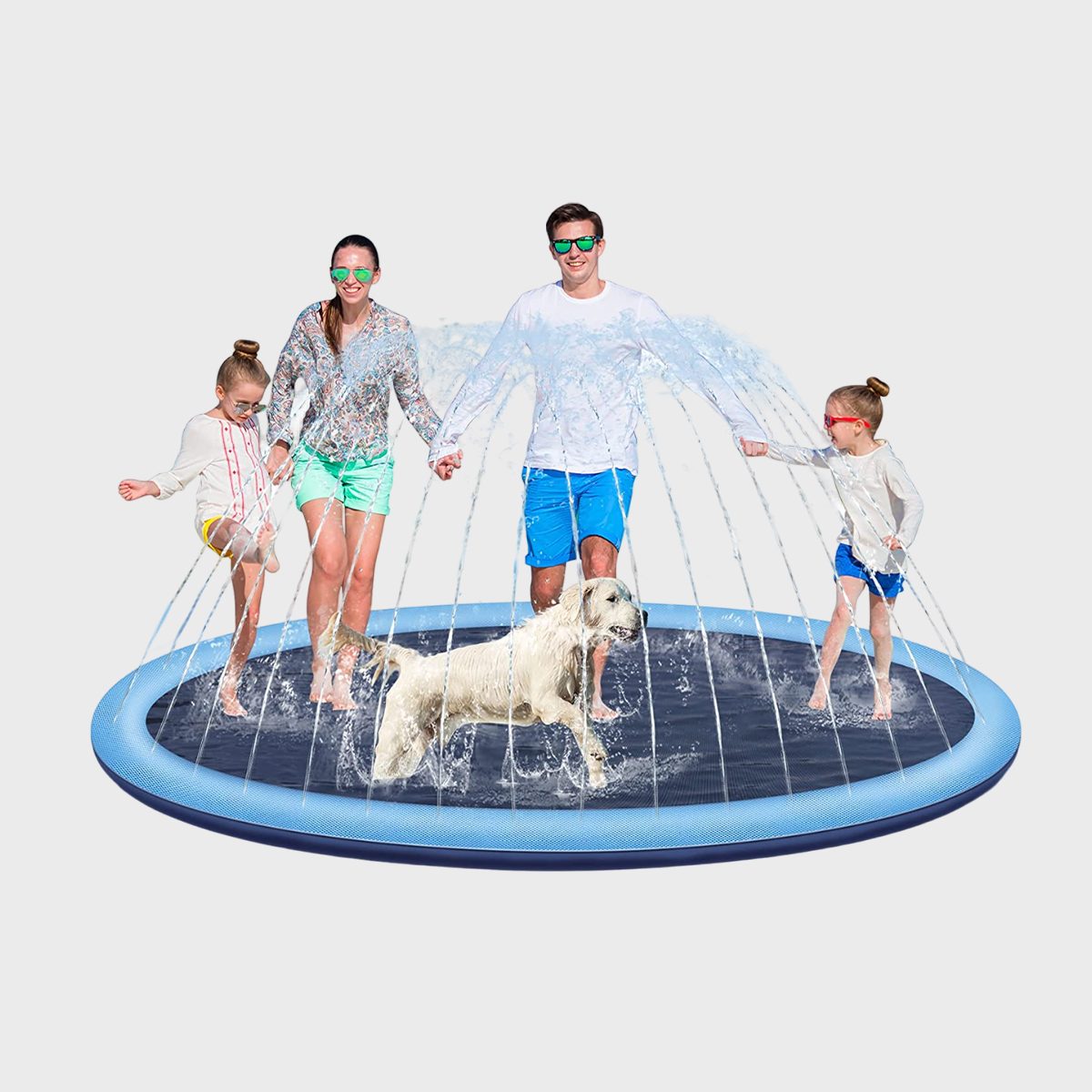 A family and dog play on a circular splash pad, with water jets arching. All wear sunglasses in a playful, summer setting.