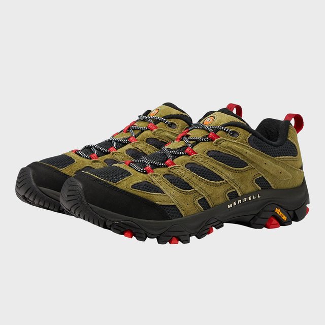 Hiking shoes feature olive green and black design with red accents, displayed in a studio setting. Text: 