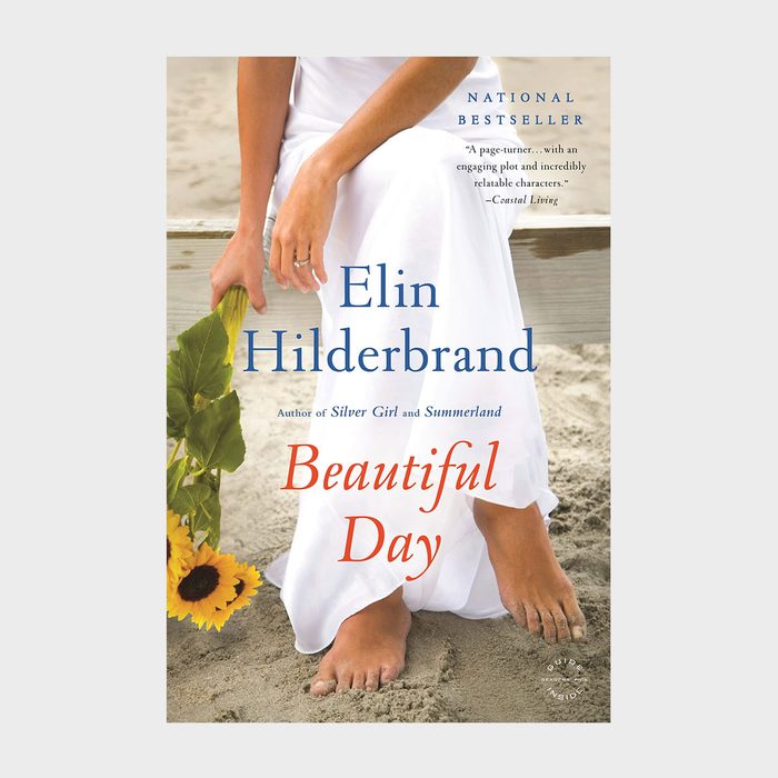 Barefoot woman sitting on sand, holding sunflowers, wearing a white dress. Text reads: 