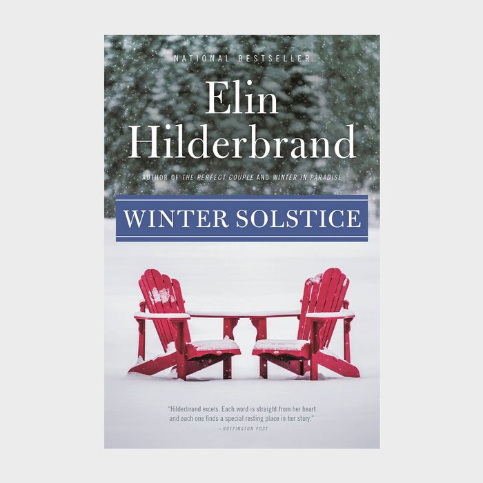 Red chairs sit facing each other, covered in snow, surrounded by a snowy landscape; book titled 