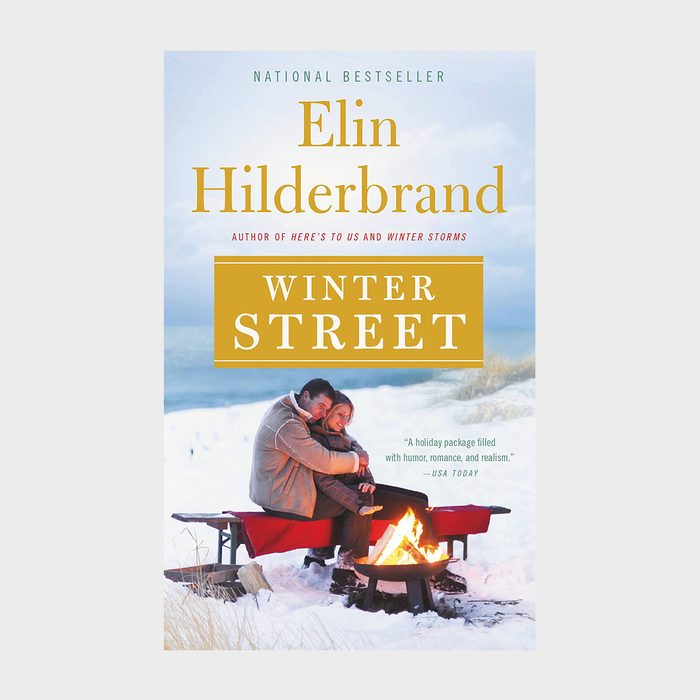 Couple embraces beside a fire pit in snowy dunes. Book cover text: 