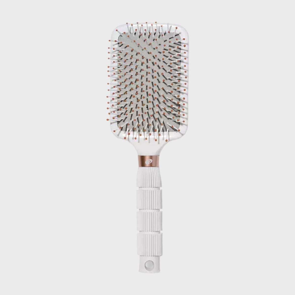 White hairbrush rests upright, displaying paddle-shaped head with bristles topped with small balls, against a plain gray background.