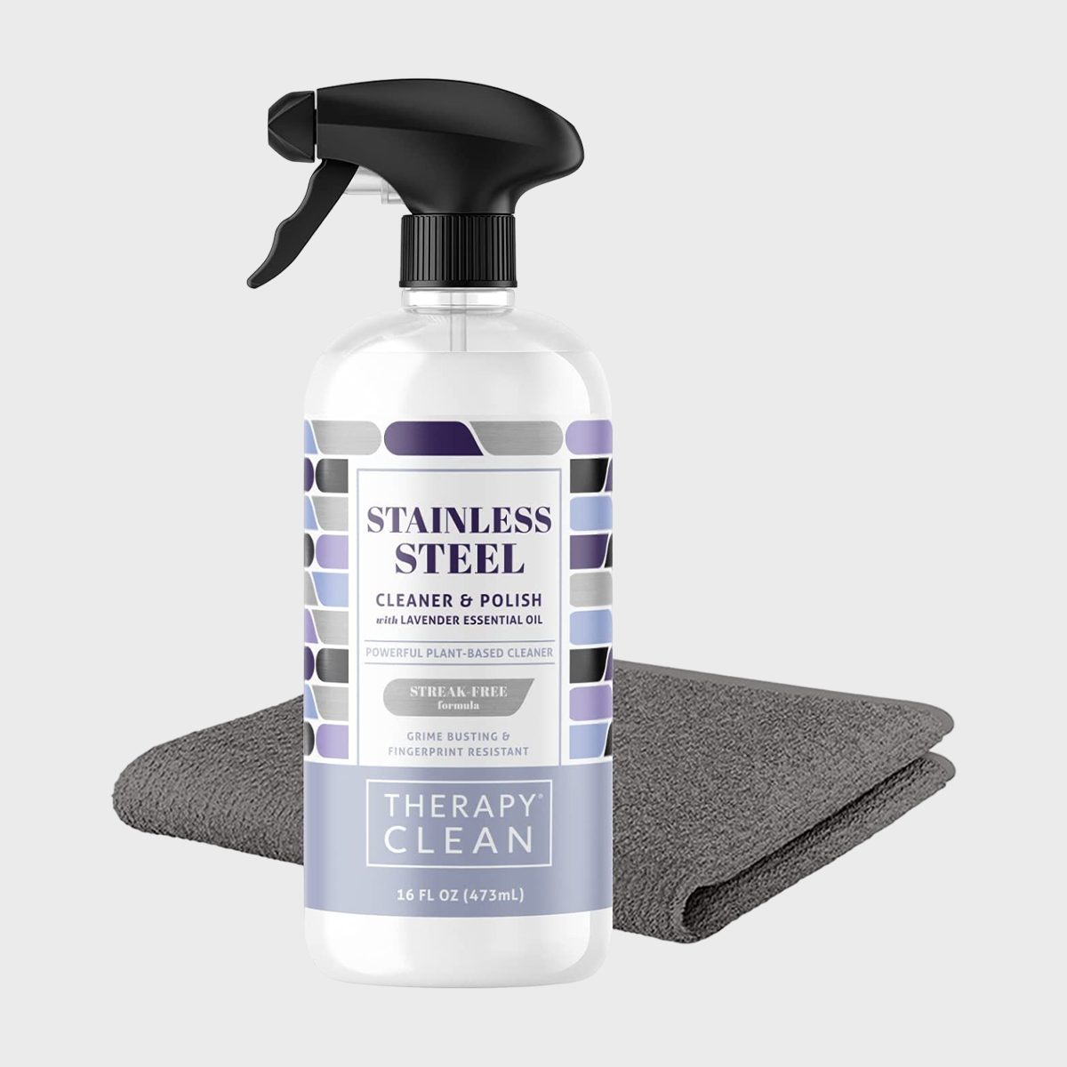 A spray bottle labeled "Stainless Steel Cleaner & Polish" sits beside a gray cloth on a plain background.