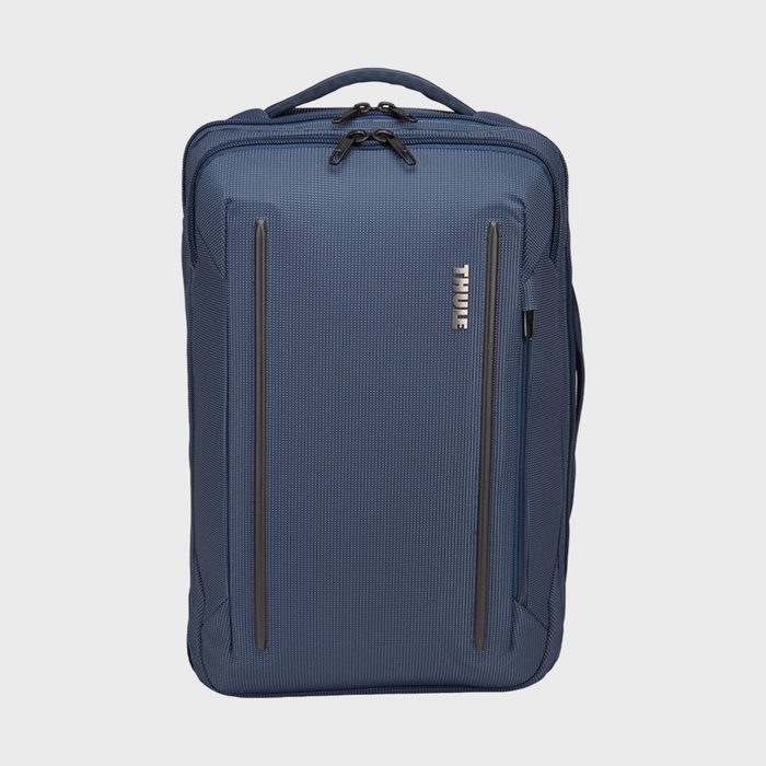 A blue backpack stands upright against a plain background, featuring dual vertical zippers and branded with 