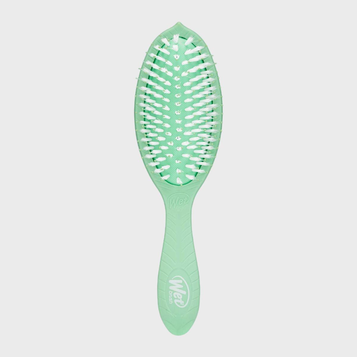 A green hairbrush with white bristles resting upright against a plain white background. Text on the handle reads, "Wet Brush."