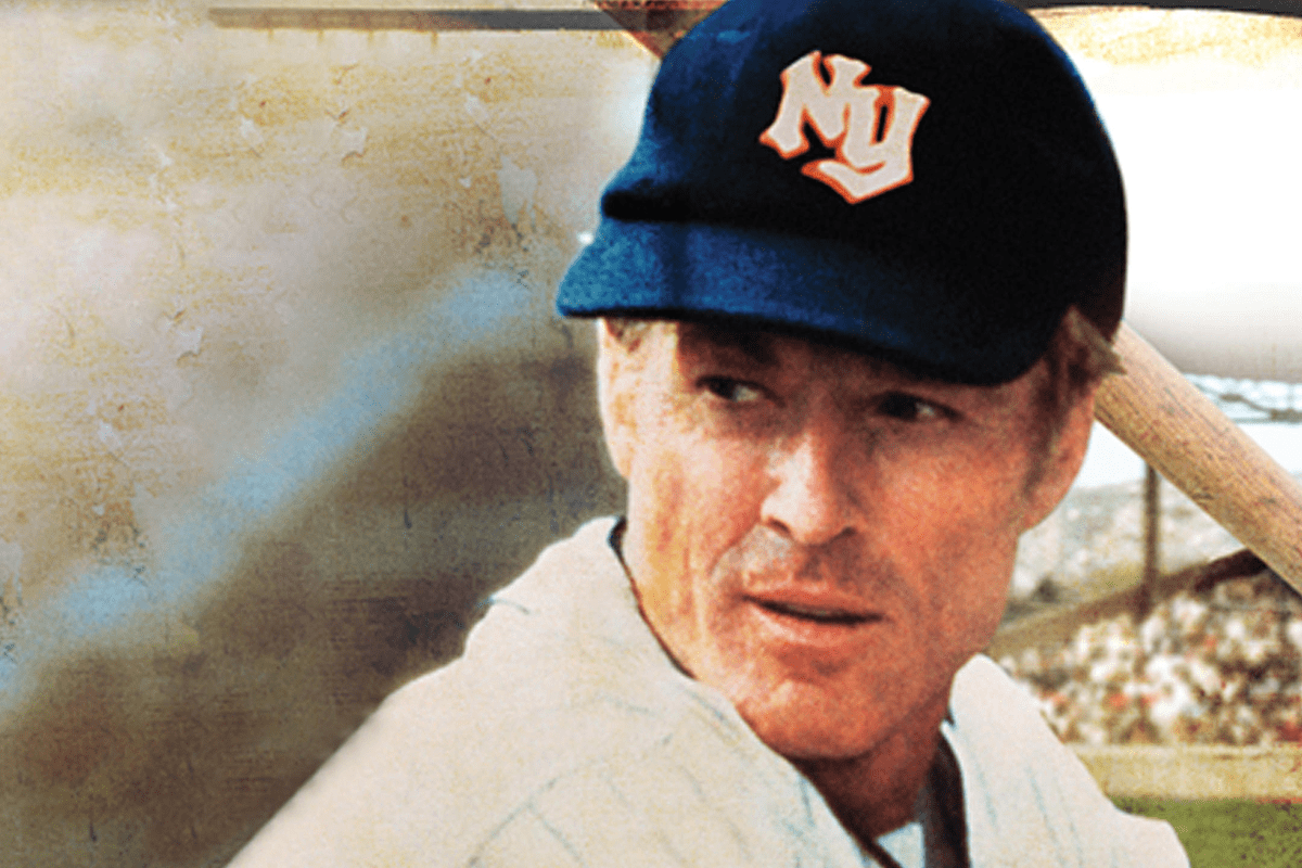 A baseball player holds a bat, wearing a blue cap with "NY" letters, set in a stadium with blurred stands filled with people.