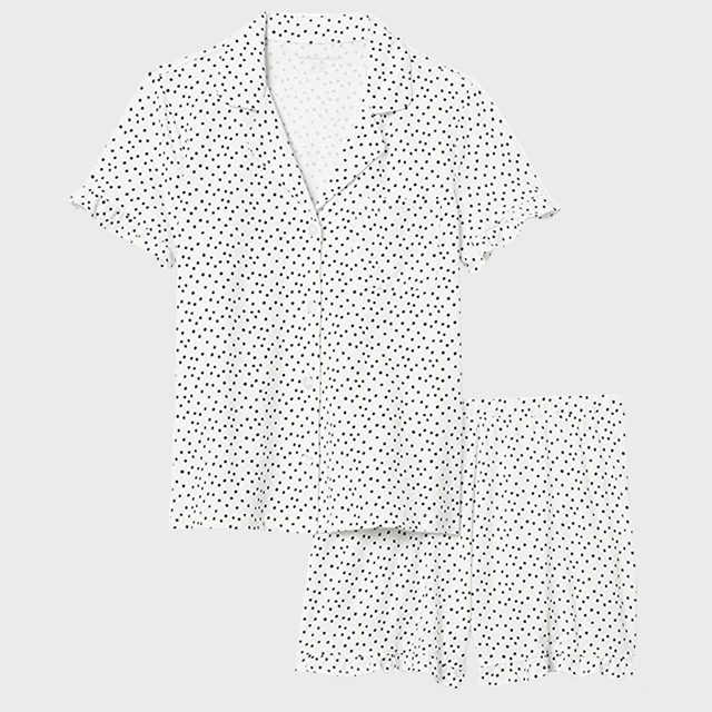 Polka dot short-sleeve shirt and shorts are laid flat on a plain surface.