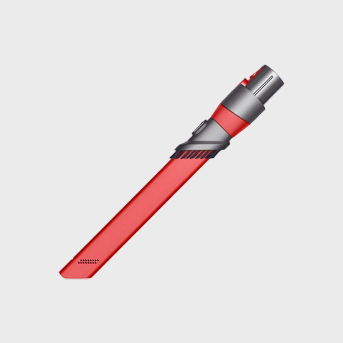 A red vacuum attachment with bristles is angled diagonally against a plain, light gray background.