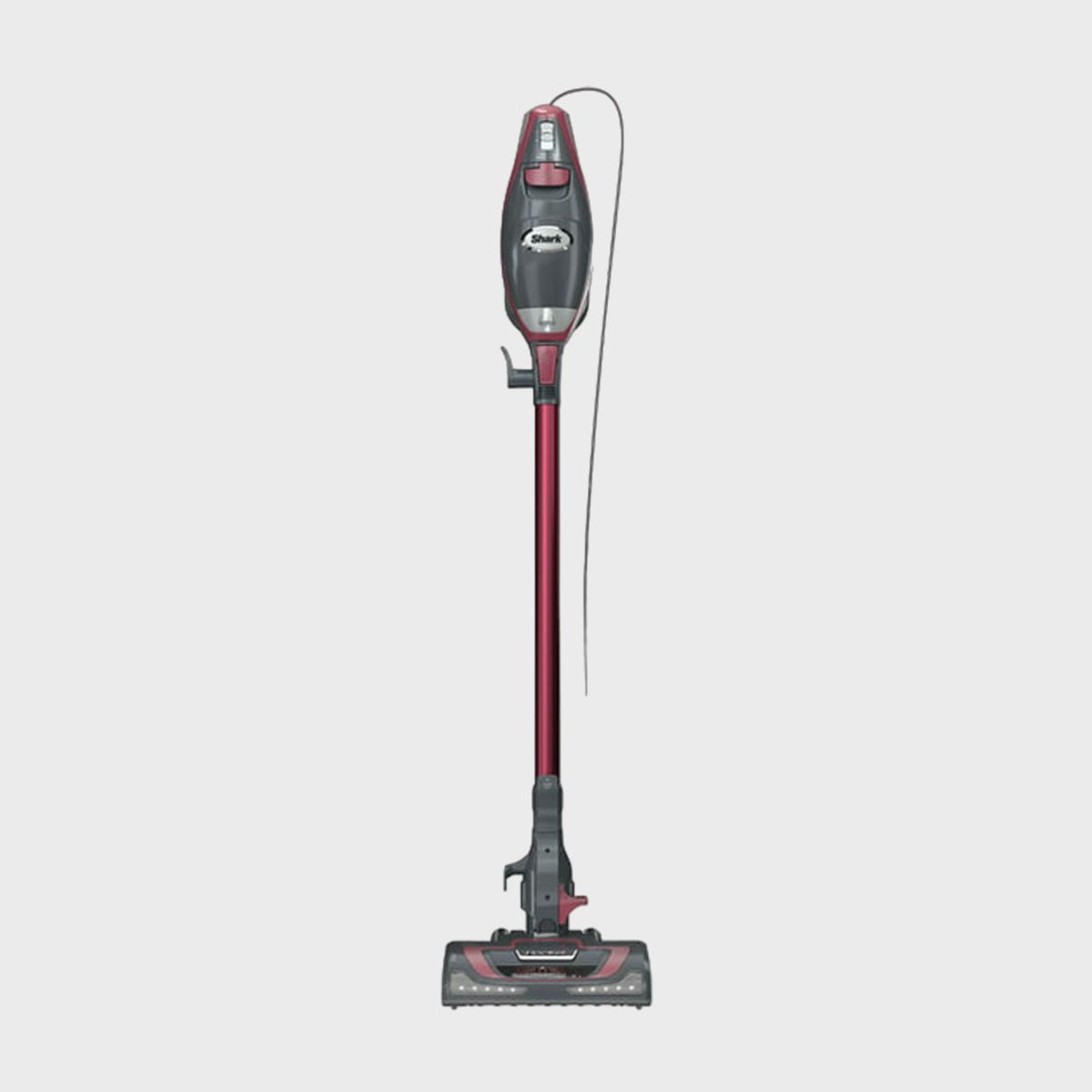 Vacuum cleaner stands upright with a red handle and black body labeled "Shark," against a plain white background.