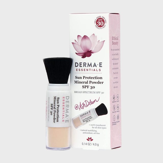A mineral powder container with attached brush stands beside its box, featuring a lotus image and text promoting sun protection, SPF 30, and ethical beauty.