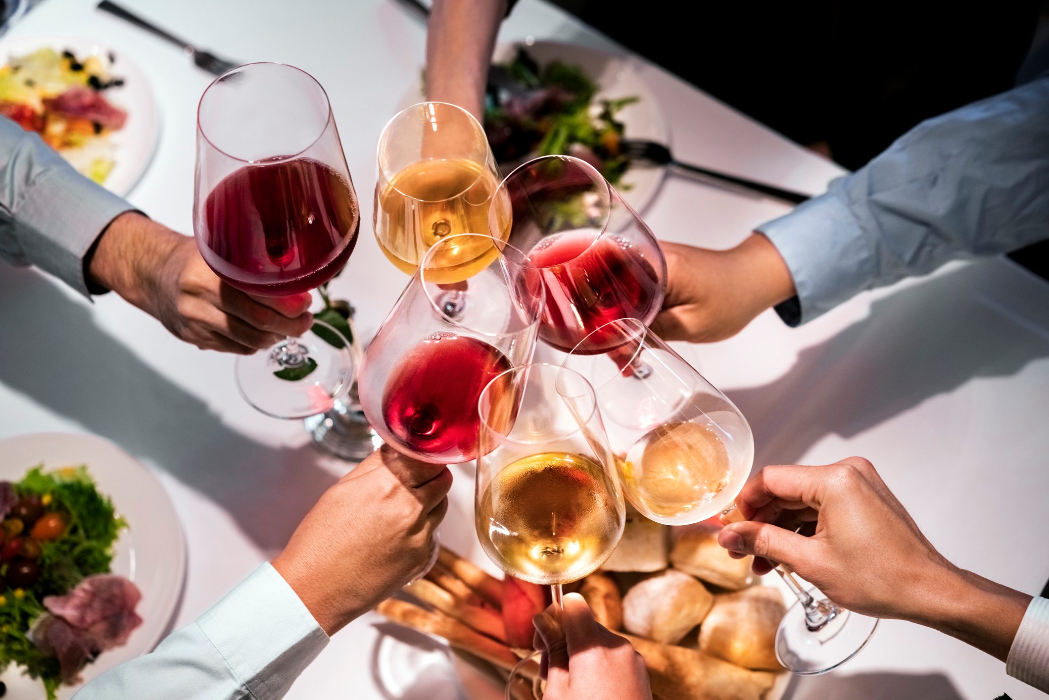 Cropped hands of executives toasting wineglasses