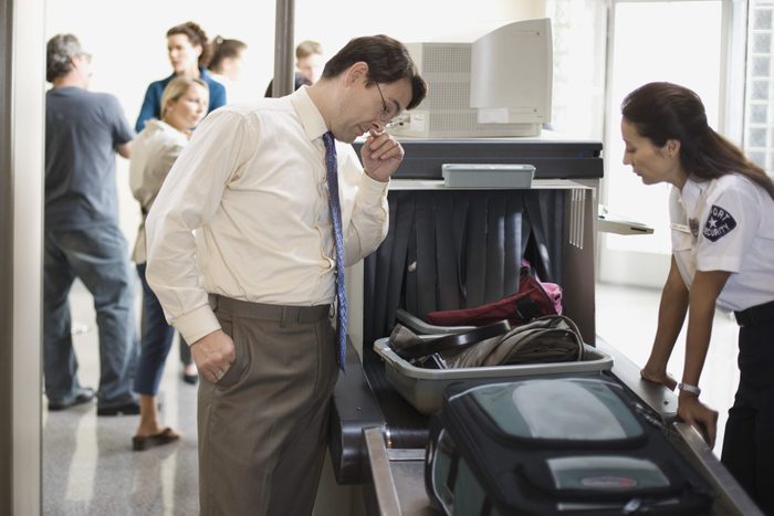 Businessman and security officer at airport security checkpoint