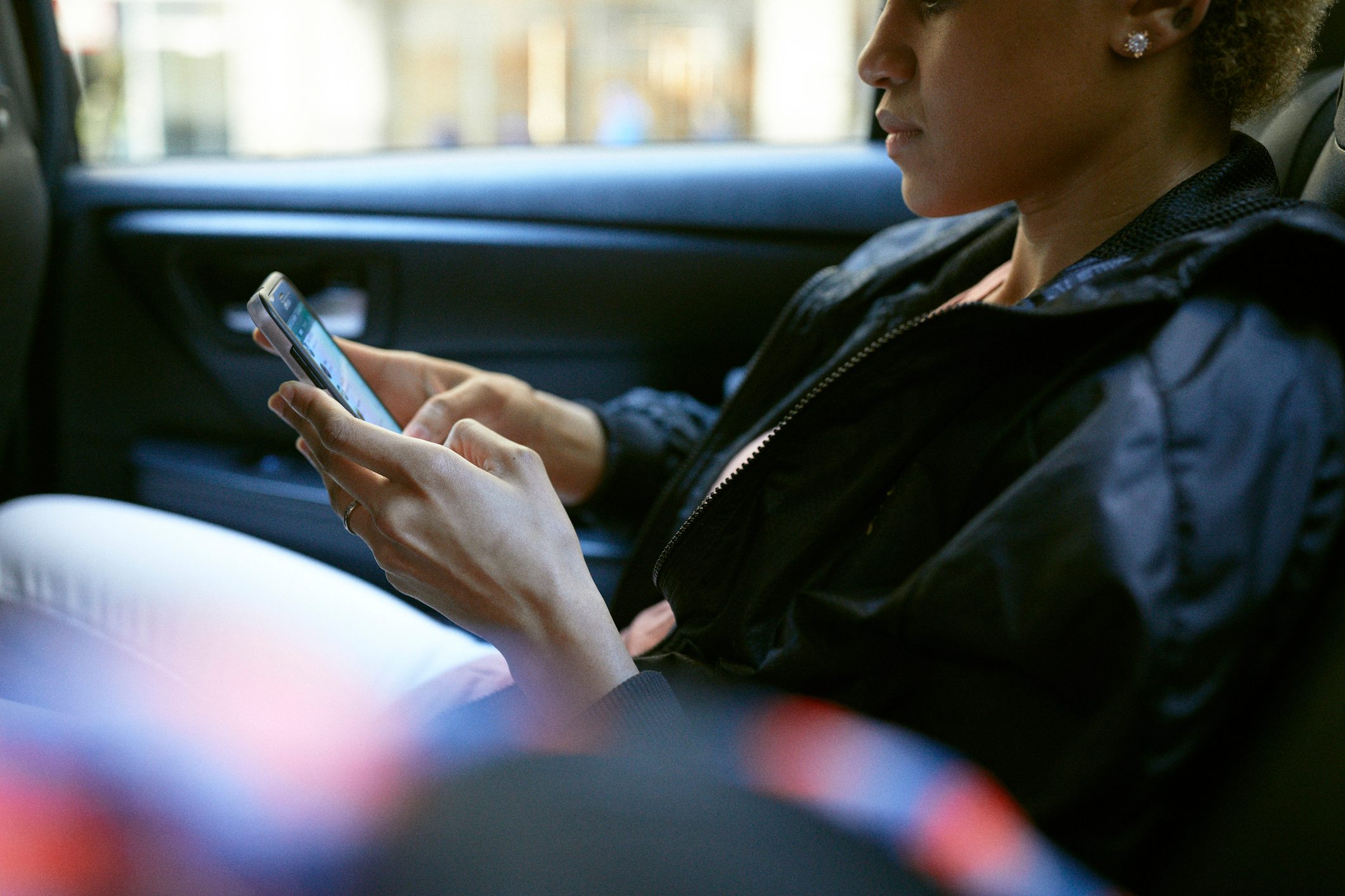 Midsection of woman using phone in taxi