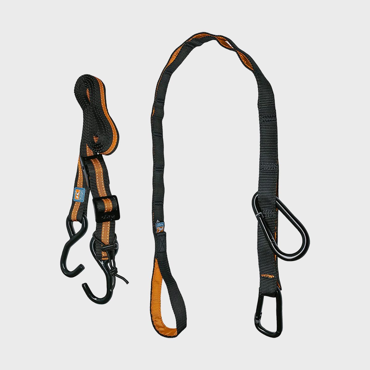 Black and orange ratchet straps with hooks are hanging, designed for securing cargo, against a plain gray background.
