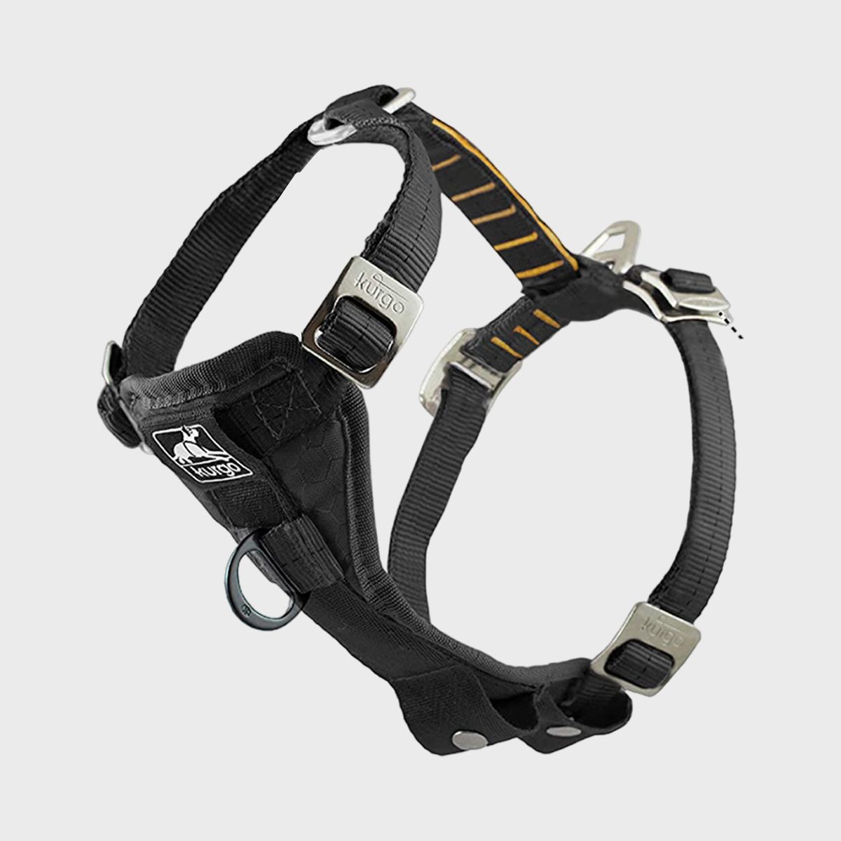 A black dog harness with metal buckles and rings, floating against a plain light gray background. The brand name "Kurgo" is visible.