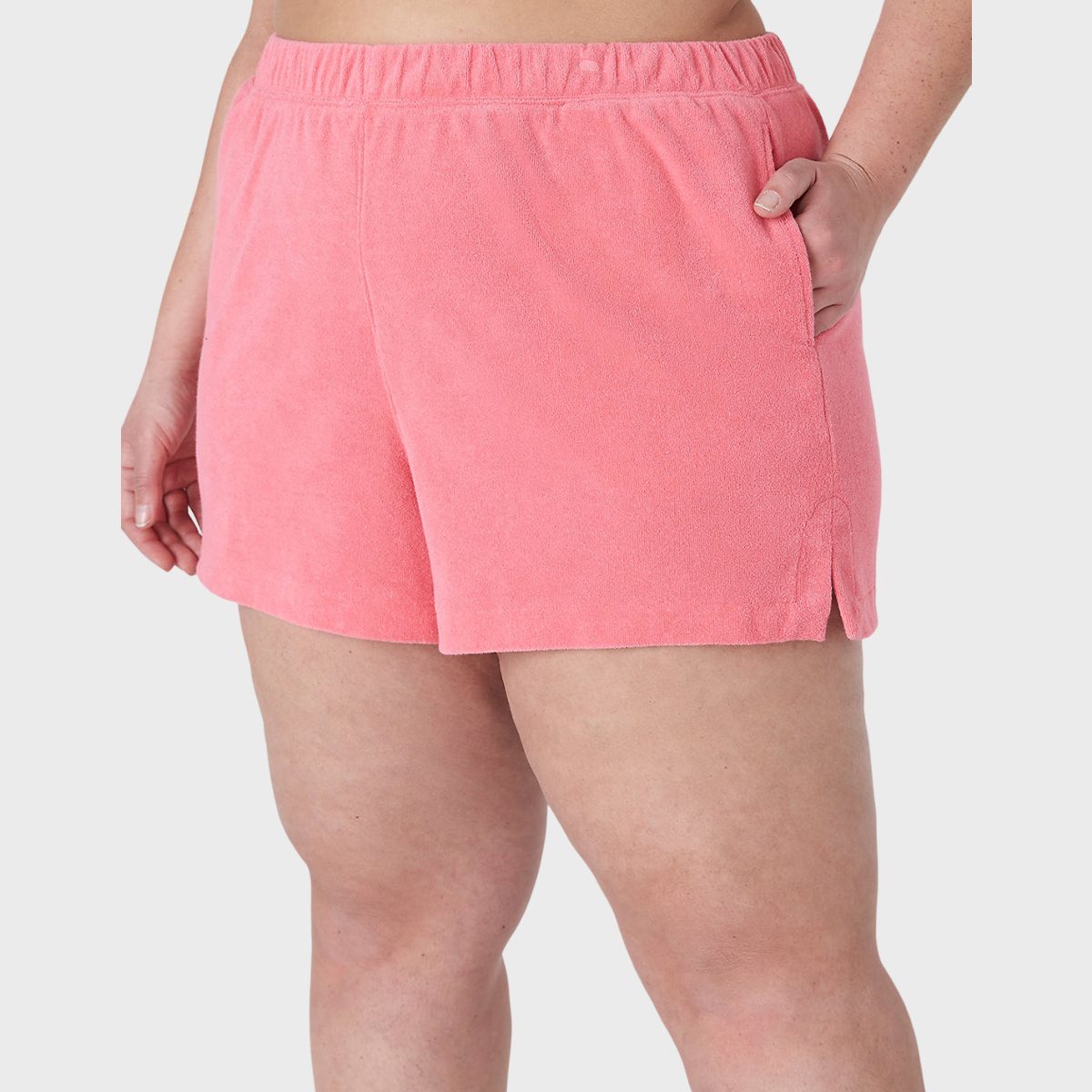 Pink shorts are worn by a person, standing with one hand in the pocket, shown against a plain white background.