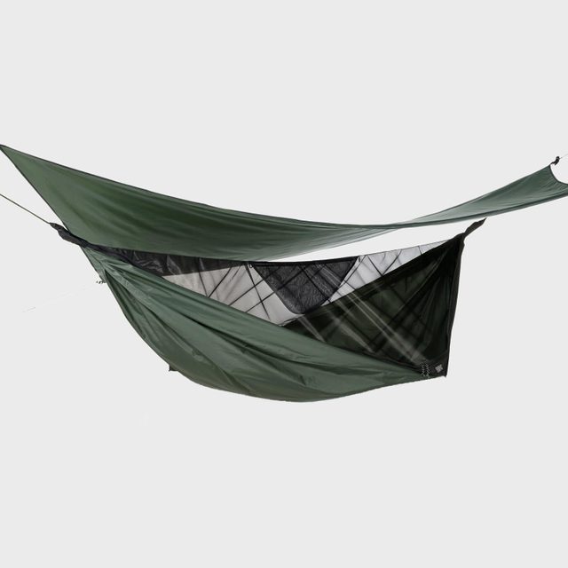 Green camping hammock hangs, revealing a netted interior, set against a plain white background.