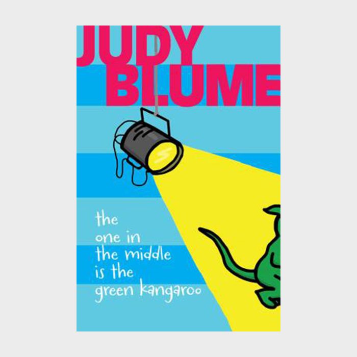 A spotlight illuminates a green kangaroo tail on a blue background; bold text reads "JUDY BLUME" and "the one in the middle is the green kangaroo."