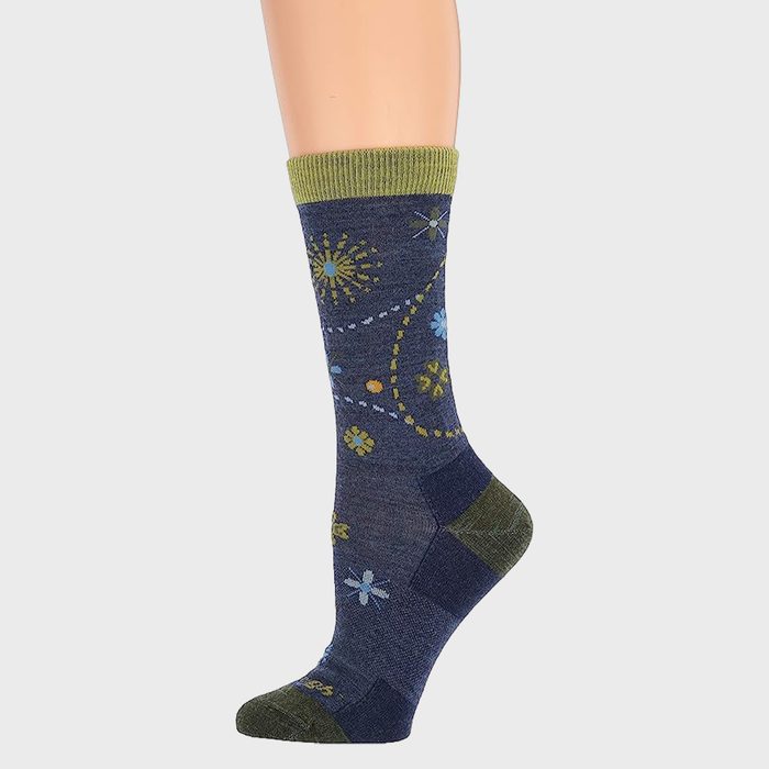 A blue sock displays floral patterns and geometric shapes, with green accents, against a plain background.