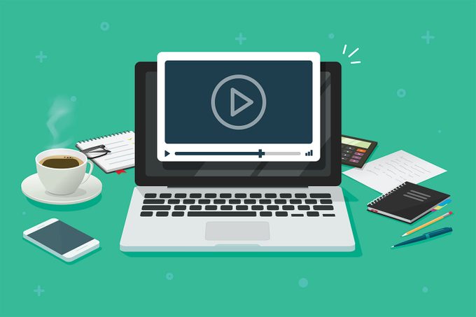 Remote Workplace Concept with Laptop, Video Player, Cell phone, calculator, office supplies and coffee to get the job done