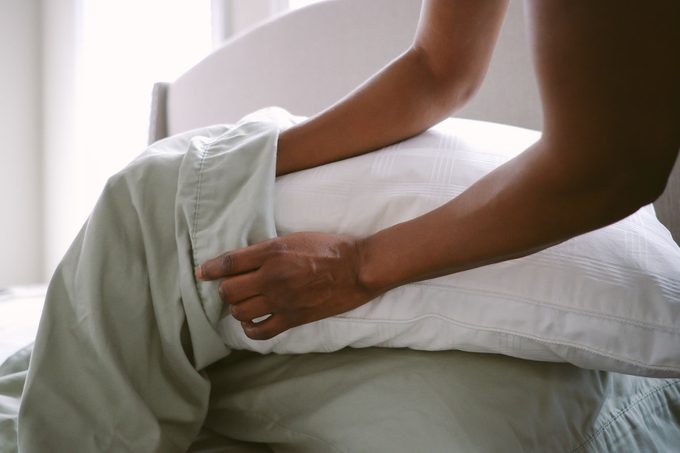 Close-up of unrecognizable woman putting pillow into freshly laundered pillowcase
