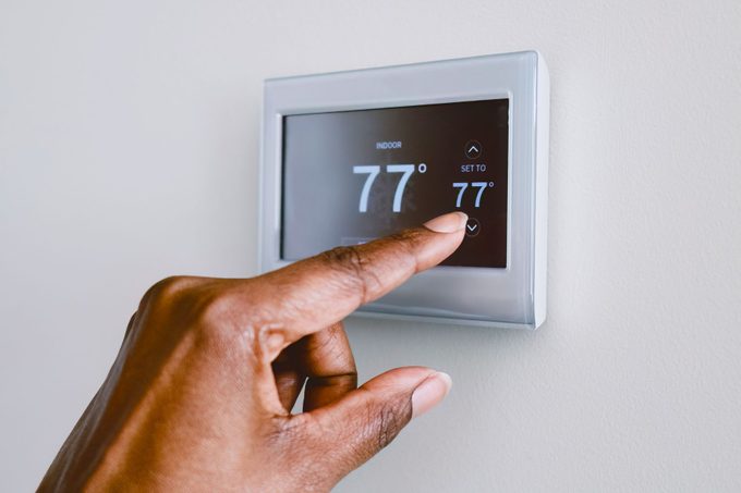 Woman Adjusts Thermostat