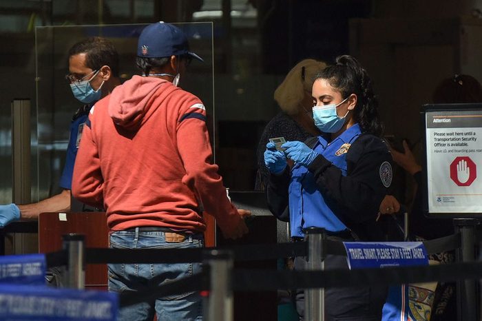 A TSA officer checks a man's ID at a screening checkpoint