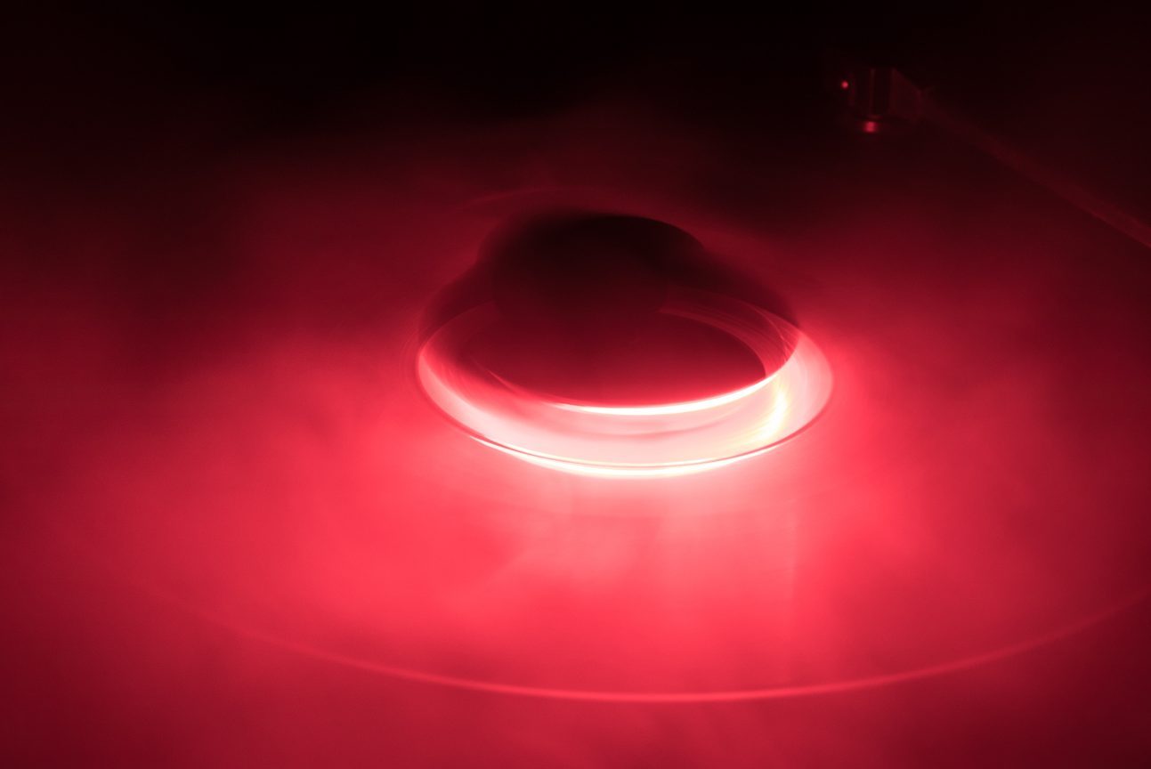 A glowing red ring emits light, surrounded by swirling mist in a dark space.