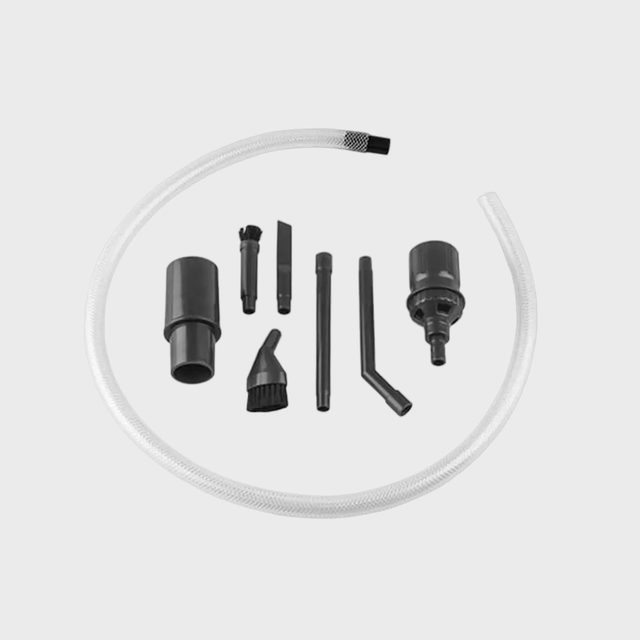 Vacuum attachment set displayed on a light background. Various black plastic nozzles and a flexible clear hose are arranged neatly.