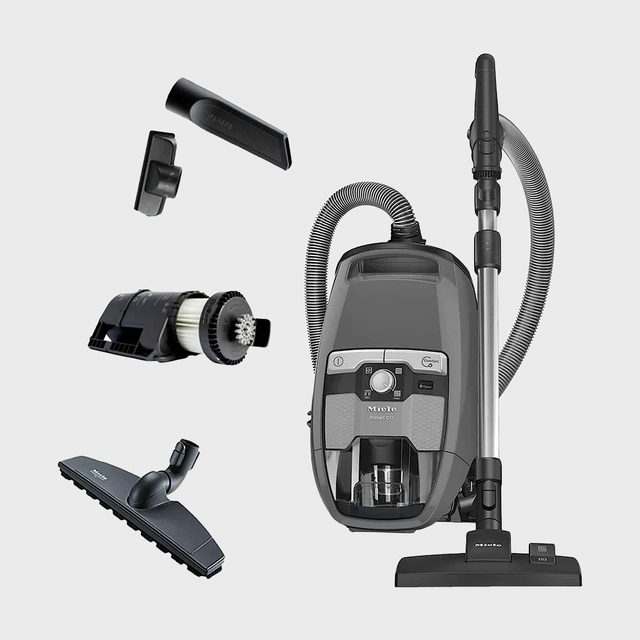 Vacuum cleaner with attachments displayed; includes hoses and cleaning tools, set against a plain background. Text: 