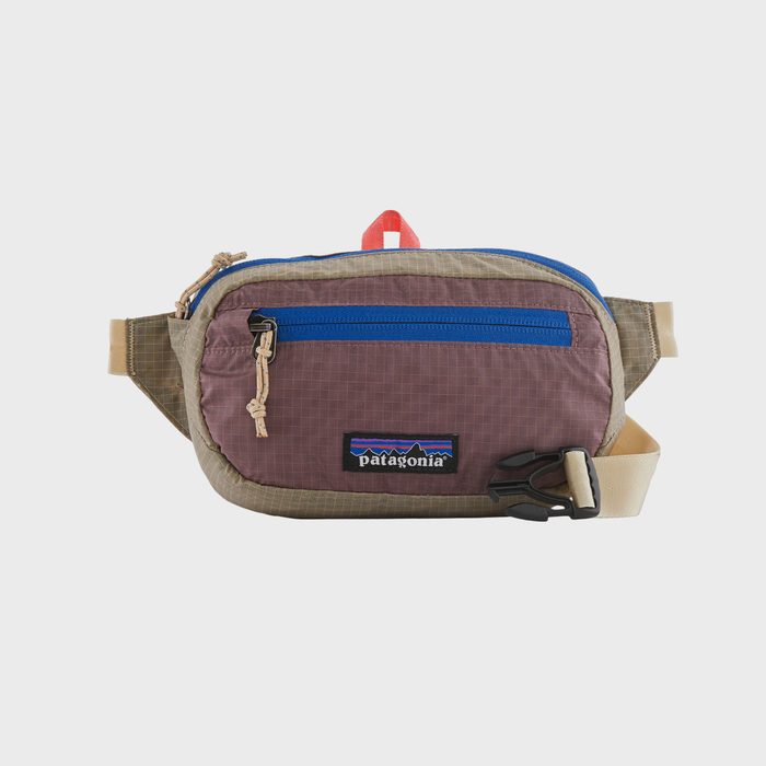 A small tan and purple waist pack with a blue zippered pocket, featuring a 