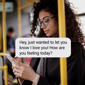 Person reads phone message; standing on public transport. Message reads: 