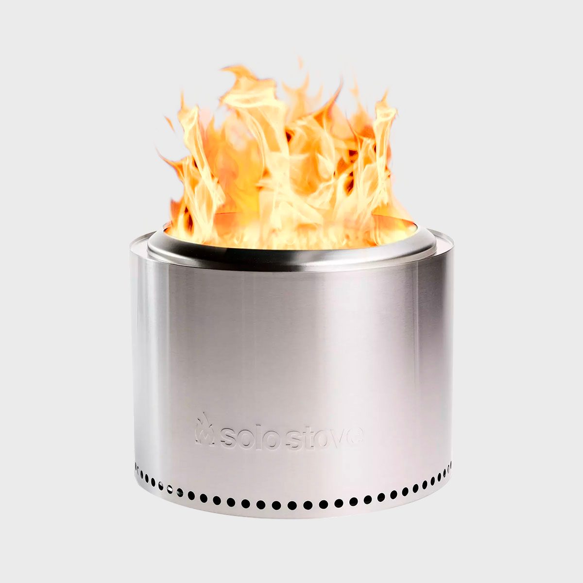 Stainless steel stove emits flames; set against a plain, light gray background. The word "solo stove" is engraved on the side.