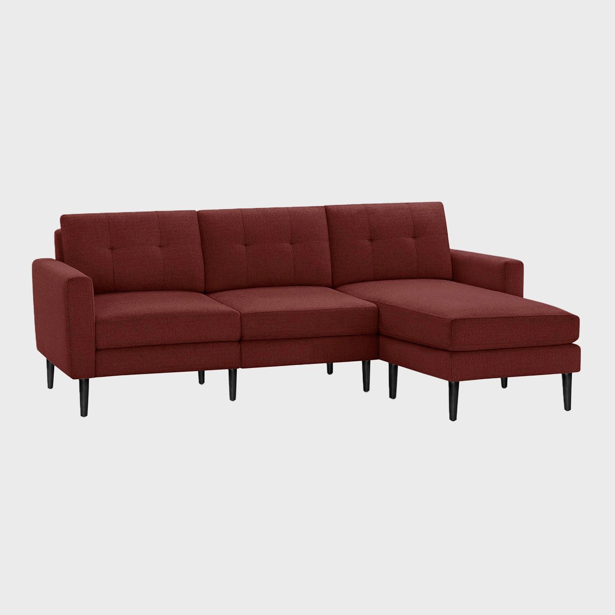 A red sectional sofa sits on black legs against a plain gray background.
